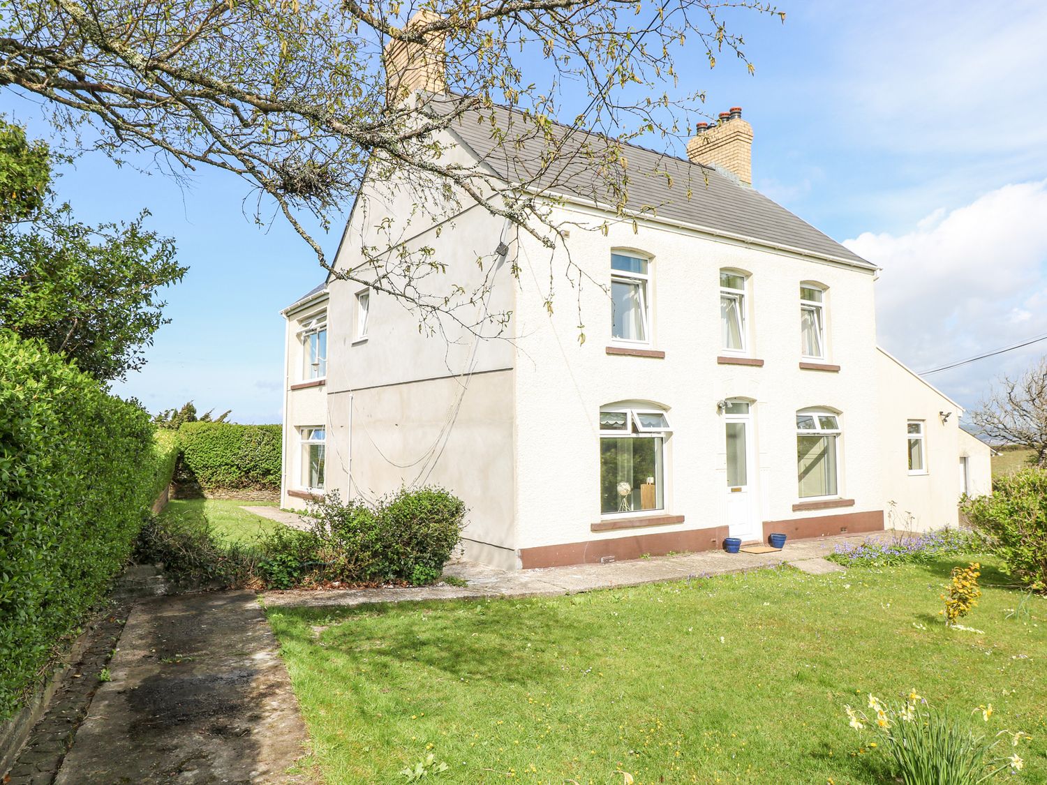 A two story house with a garden and pathway surrounded by hedges at Burry House in Llanmorlais