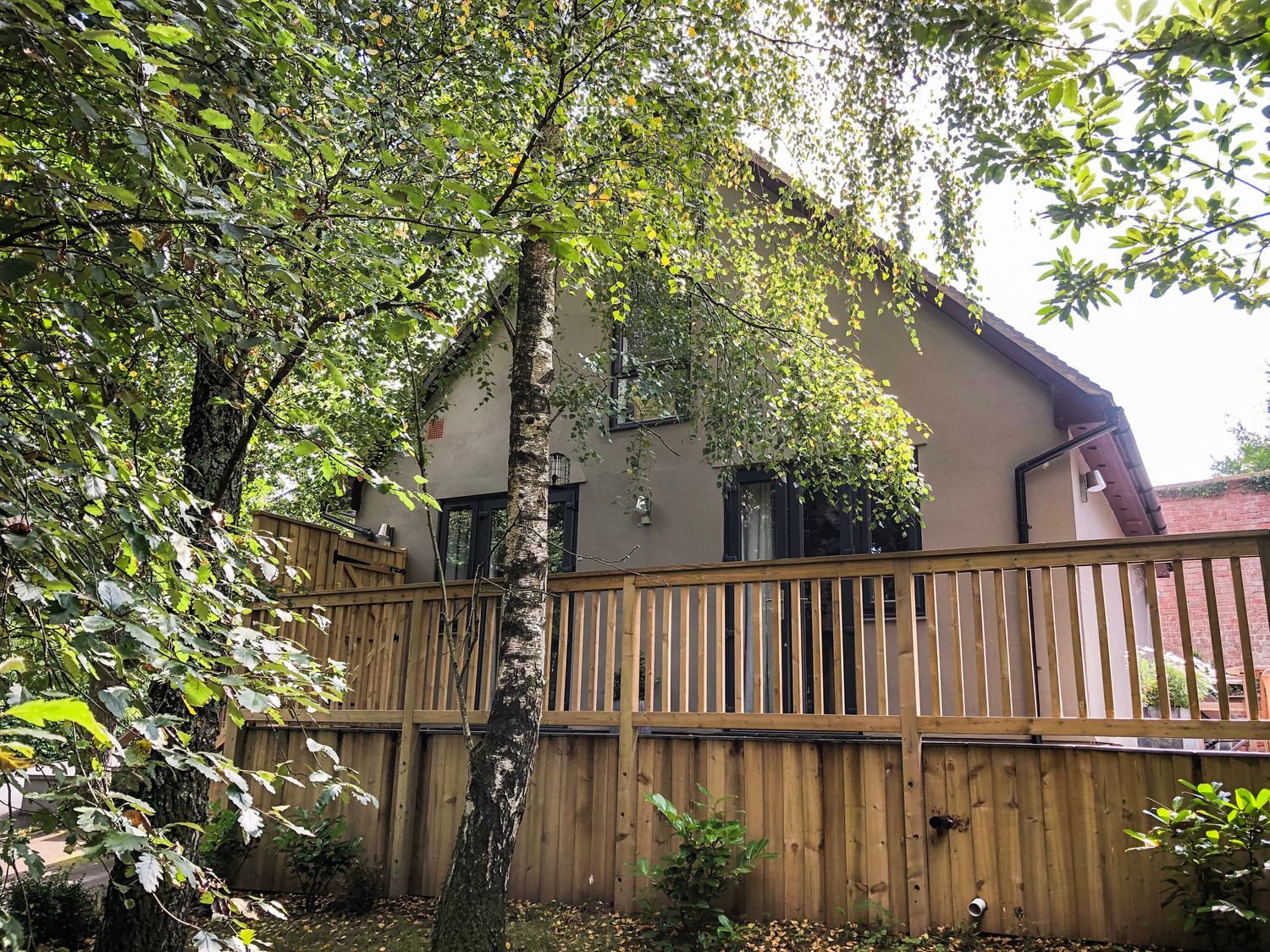 A house with a wooden fence surrounded by trees at Treetops in Southerton