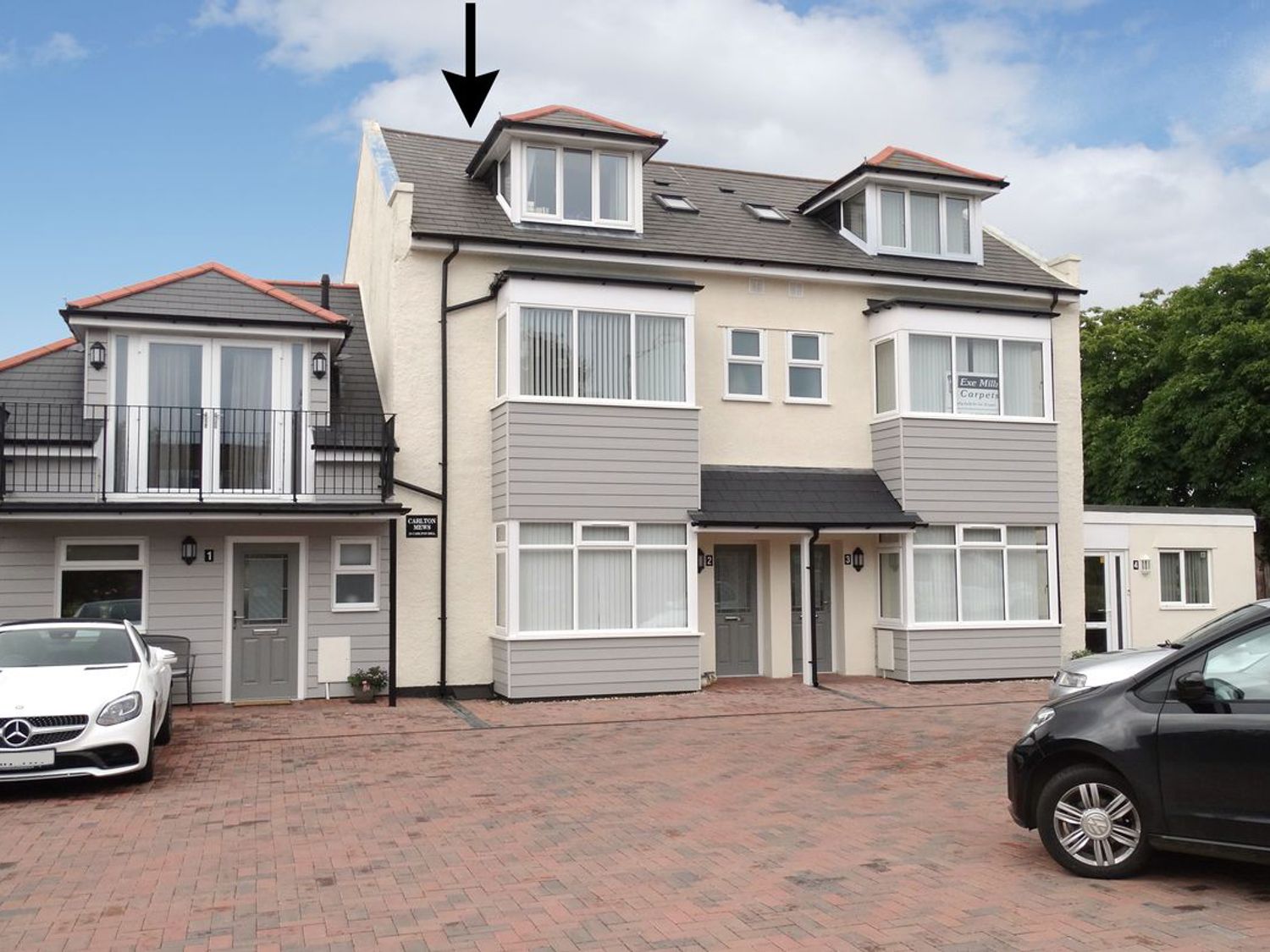 A multi-unit residential building with parked cars in front at 2 Carlton Mews in Exmouth