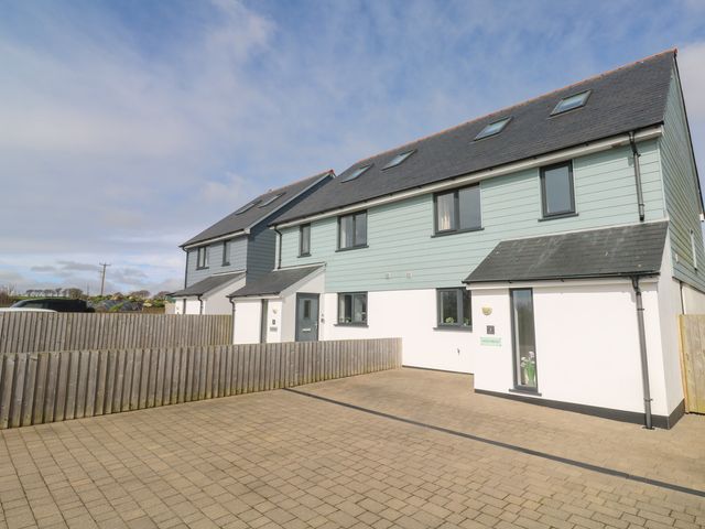 A row of modern two storey houses with grey roofs and blue siding at Ocean Breeze in Marazion