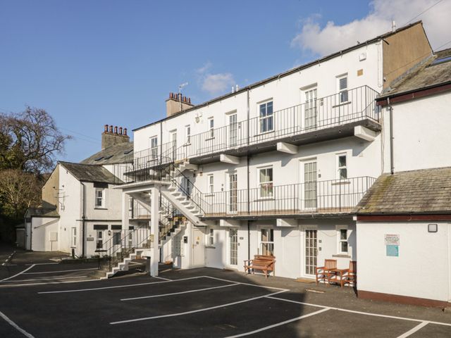 The exterior of a white multi-story building with outdoor stairs a parking lot and benches at Oak View in Keswick
