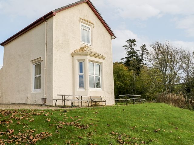 Exterior of a two-story house with a white facade and bay window with benches and tables on the grass at Riechip Butterstone near Dunkeld