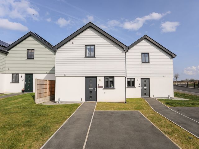 Two adjoining houses with pathways and grass lawns at Y Ty Pren in Brynteg near Benllech