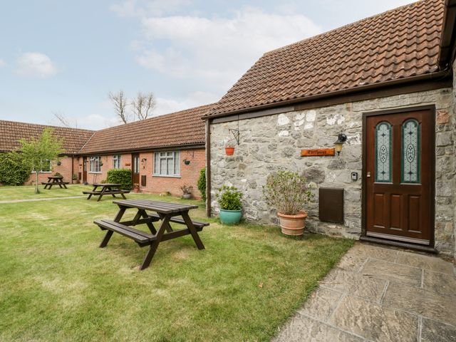A courtyard with picnic tables and stone and brick buildings at Carthouse in Brean