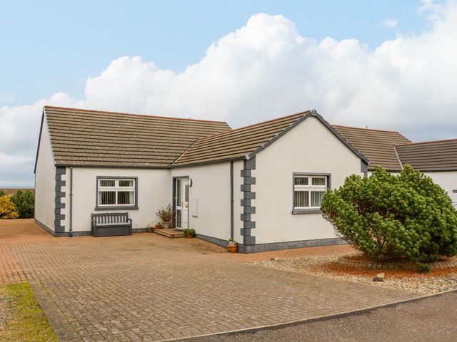 A single-story house with a paved driveway and a small garden area at Strandview in Castlerock