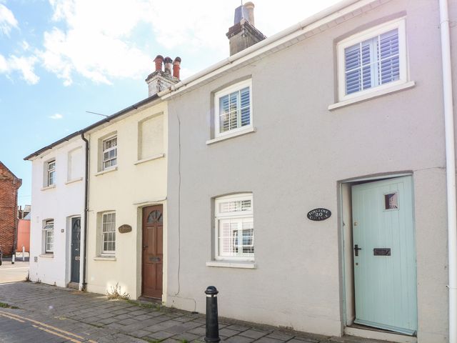 A street view of three connected houses with doors and windows at Foxglove Cottage in Christchurch