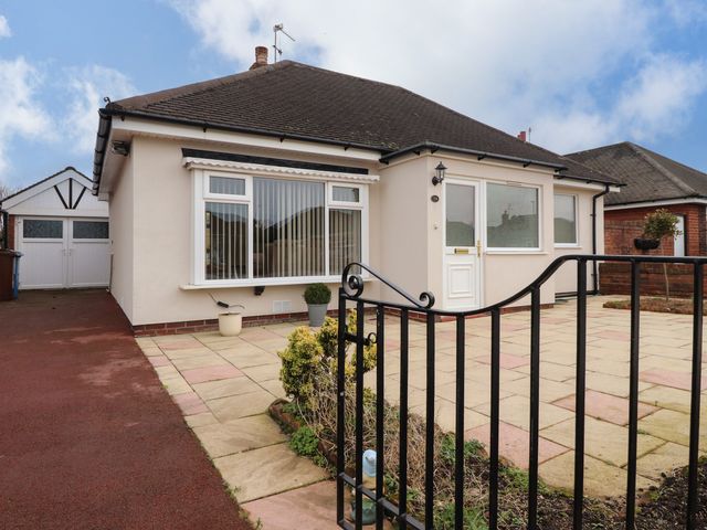 A single-story house with a front patio and driveway with a garage at 14 Berwick Road in Lytham St Annes