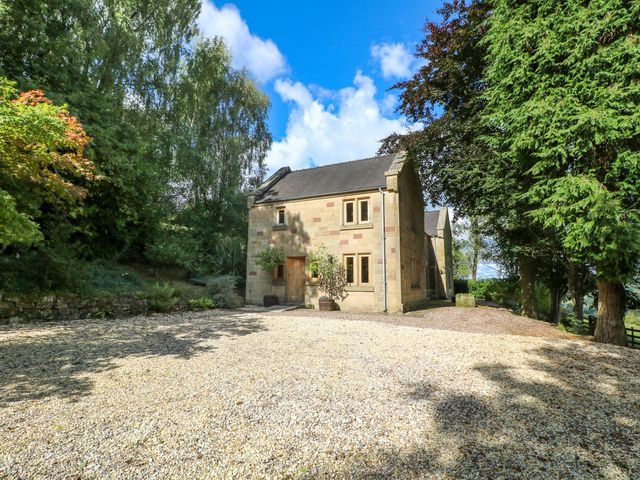 A stone house with gravel driveway surrounded by trees at Chapelfield in Alderwasley near Wirksworth
