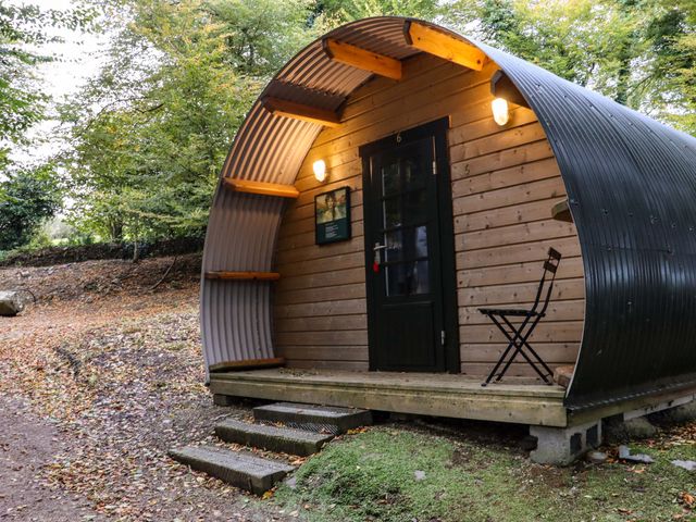 A small wooden pod with curved metal roof and a black door with steps and a foldable chair outside at Ballybeg Pod 9 Ballybeg near Tinahely County Wicklow