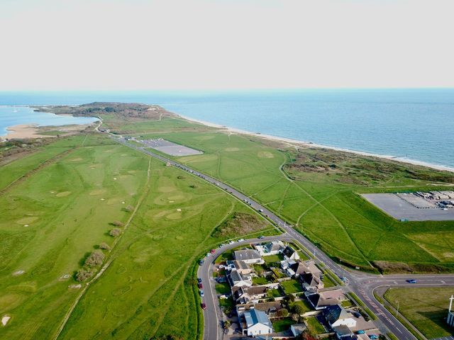 A coastal area with a golf course a road and a residential neighborhood at Bayview Cottage in Southbourne