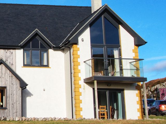 A modern house with a balcony and glass doors and windows at Tobson in Lingerbay near Leverburgh
