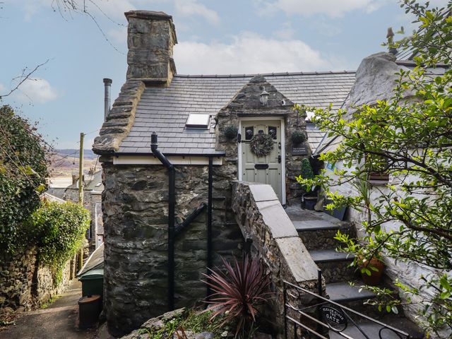 A stone cottage with a small staircase leading to a front door with a wreath at Top Cottage in Barmouth