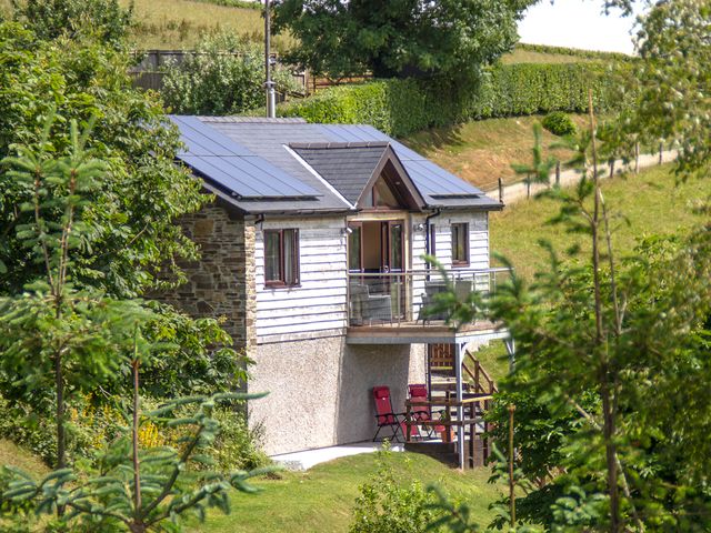 A small house with solar panels on the roof and a balcony in a green rural area at Black Mountain View in Llanafan Fawr near Builth Wells