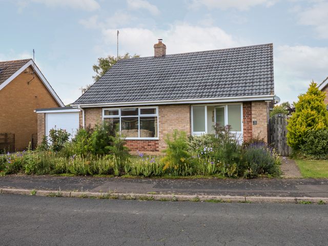 A single-story house with a pitched roof a front garden and a driveway at Newby in Gayton near King's Lynn