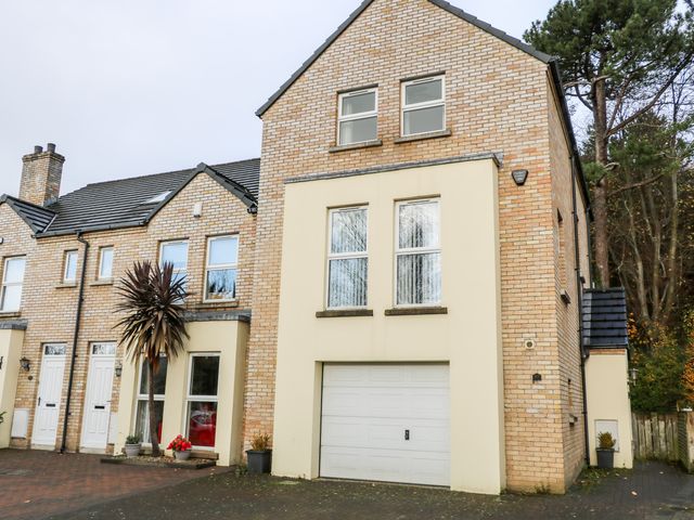 A brick townhouse with a garage and adjacent houses at The Admiral in Coleraine