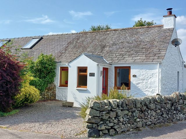 A single story cottage with white walls stone roof and a stone wall in front at Edge Hill in St Johns Town Of Dalry