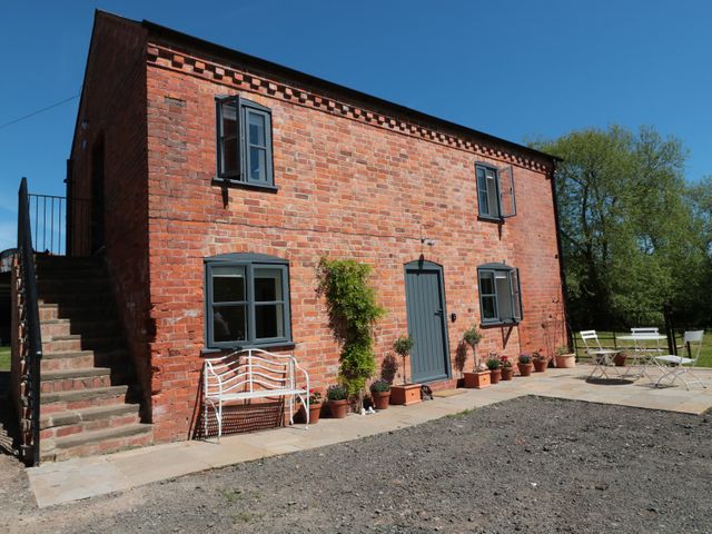 A brick house with blue doors and windows with stairs and outdoor seating at Granary 2 in Madley