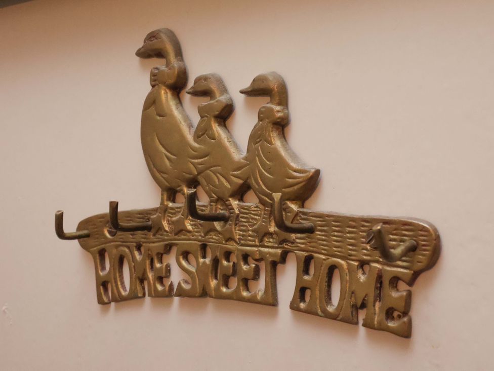 A metal wall hook with three ducks and the words home sweet home