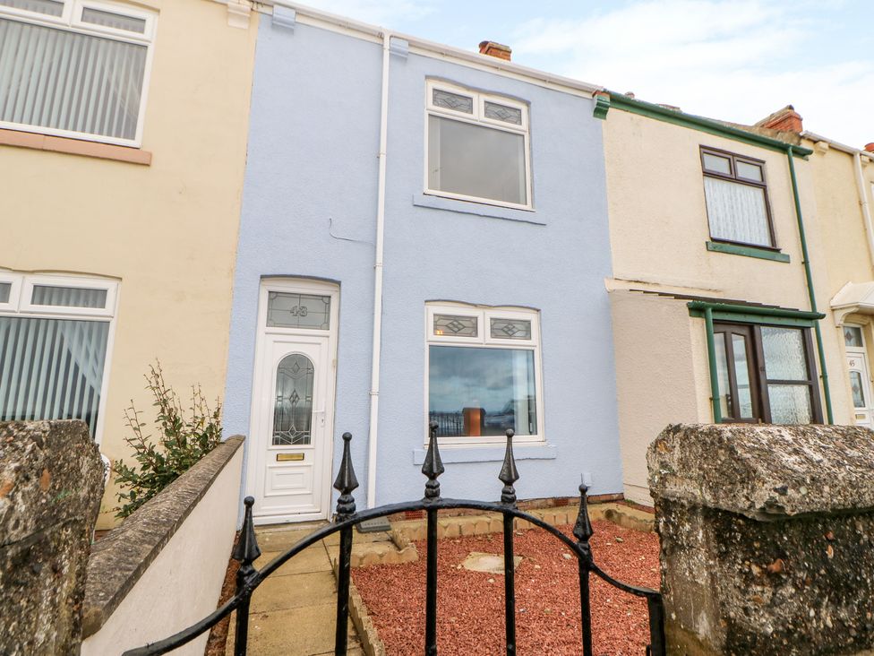 A row of terraced houses with one painted blue and a small front yard with a black iron gate at Twitchers Rest in Hartlepool County Durham