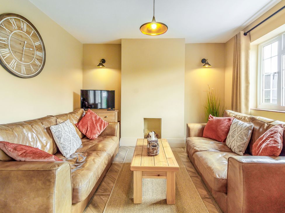 A living room with two brown leather sofas and a wooden coffee table at Ivet Lowe in Hopton near Wirksworth