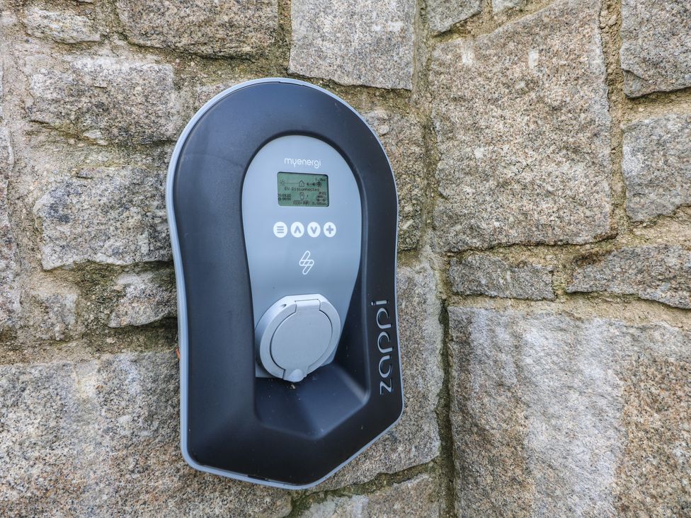 A myenergi zappi electric vehicle charger mounted on a stone wall at Stargazy Cottage in Praa Sands