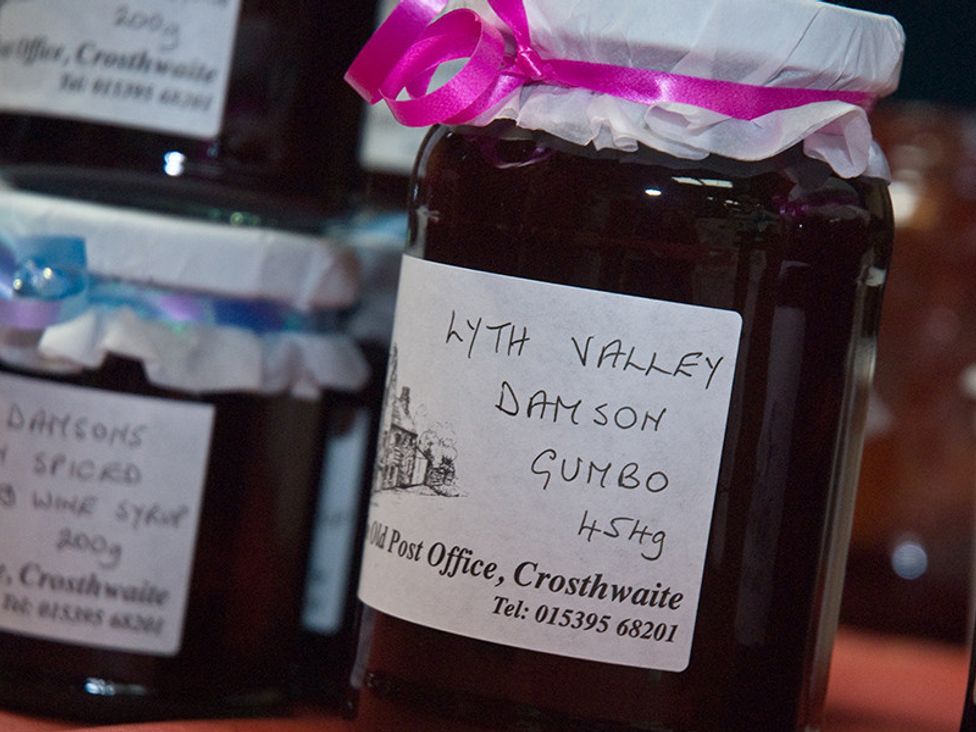 A close up of jars with handwritten labels on a table at Tipsy Gin Cottage Crosthwaite