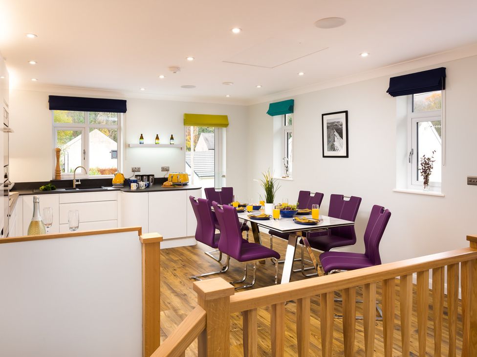 A kitchen and dining area with purple chairs and wooden flooring at Fell View in Keswick