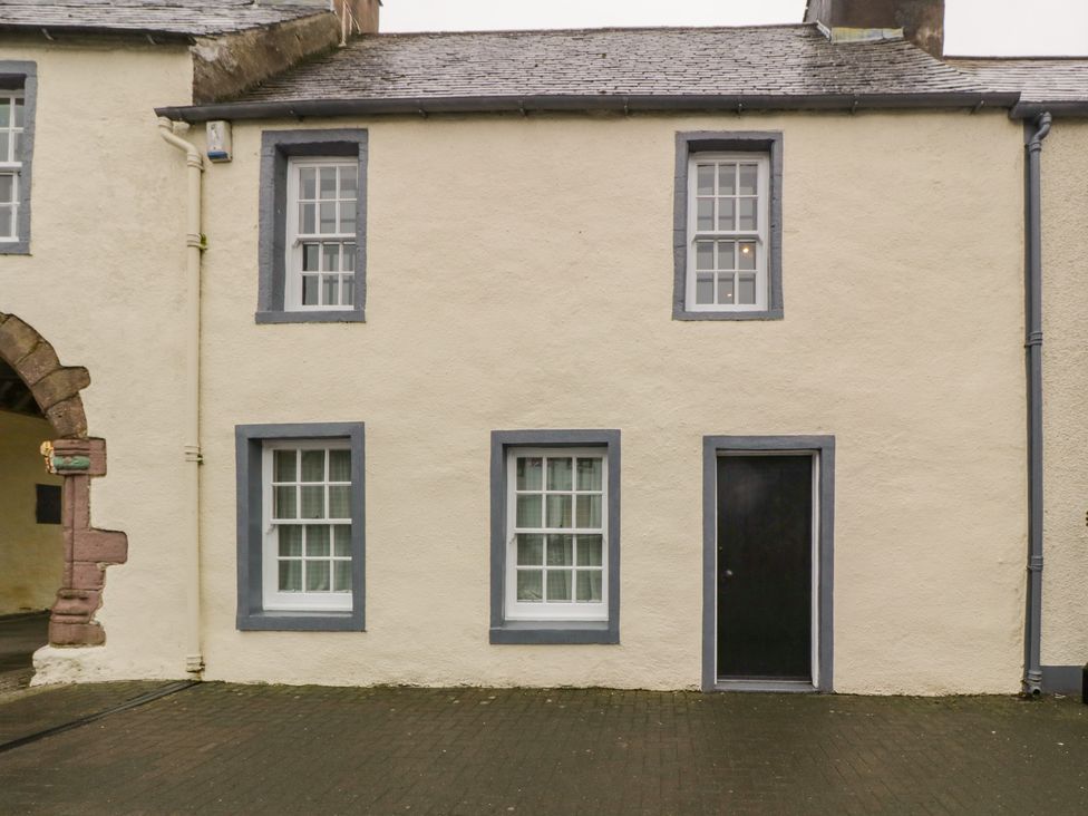 A beige building facade with four windows and a black door at The Pend in Whithorn