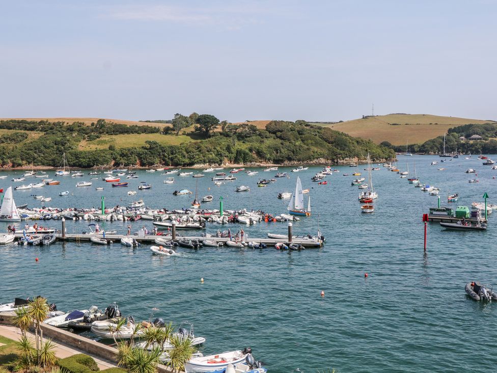 A harbor with many boats docked and floating on the water with green hills in the background at 34 The Salcombe in Salcombe