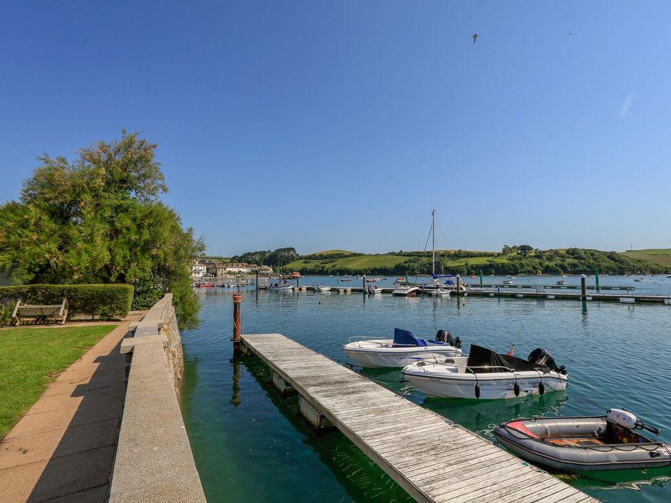 A view of a dock with boats on the water and green hills in the background at 34 The Salcombe in Salcombe
