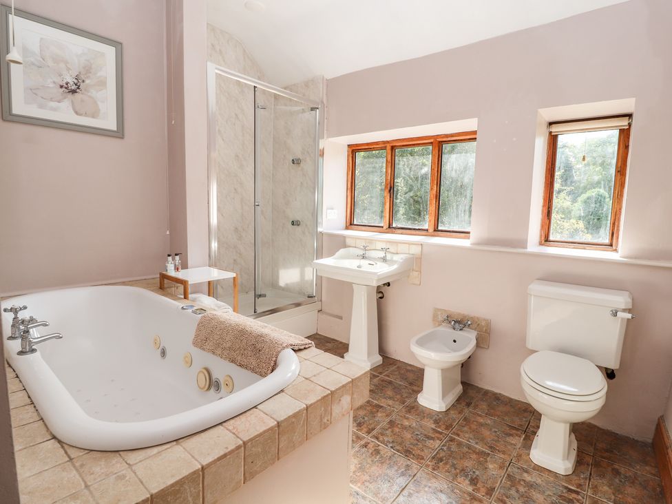 A bathroom with a bathtub shower sink bidet and toilet at Abbey Cottage in Denbigh