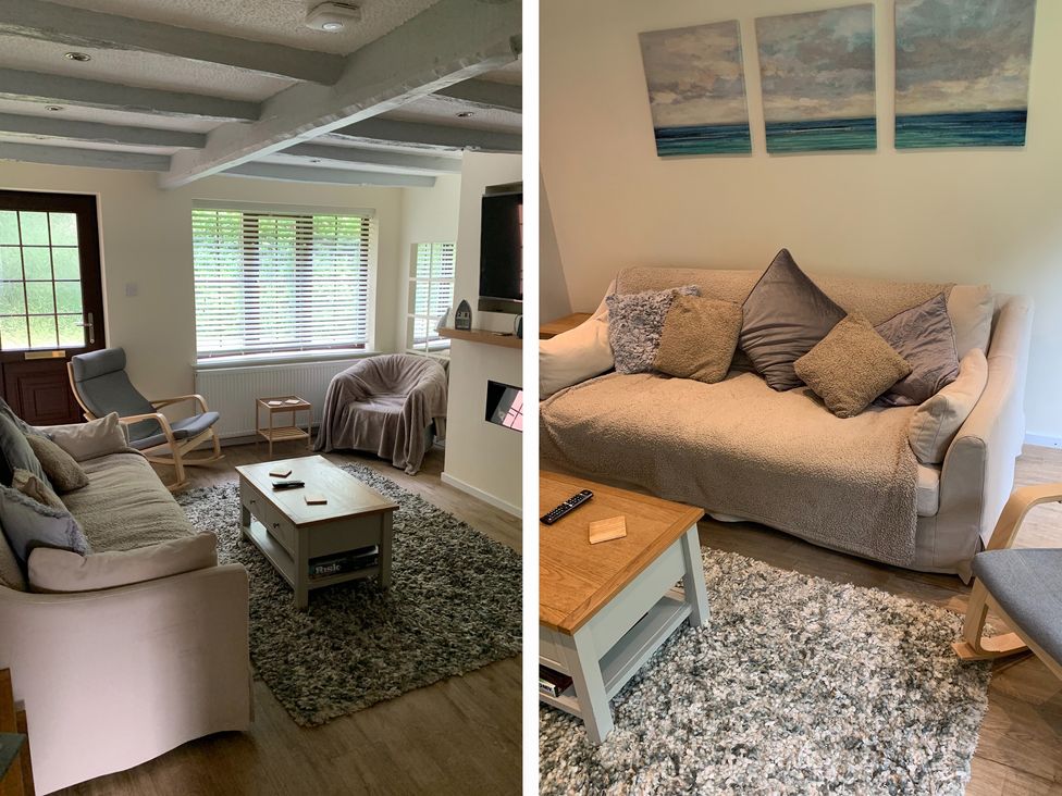 A living room with sofas chairs a coffee table and paintings on the wall at Seashells Cottage in Lytham St Annes