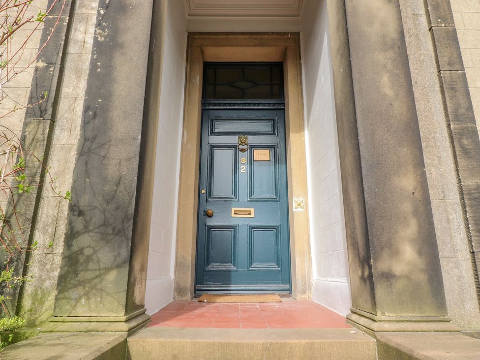 A blue front door with the number 2 on it set between two large stone columns at Windyridge in Settle