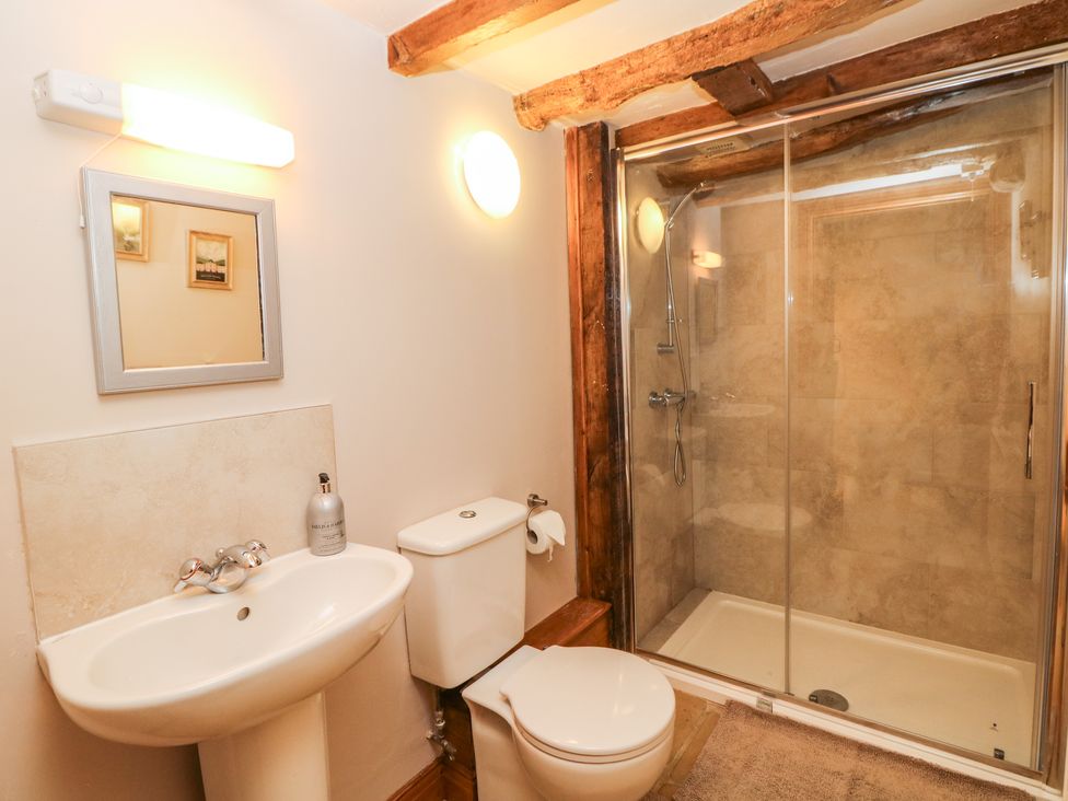 A bathroom with a pedestal sink toilet and glass-enclosed shower at Green Farm Stables in Hognaston near Carsington Water