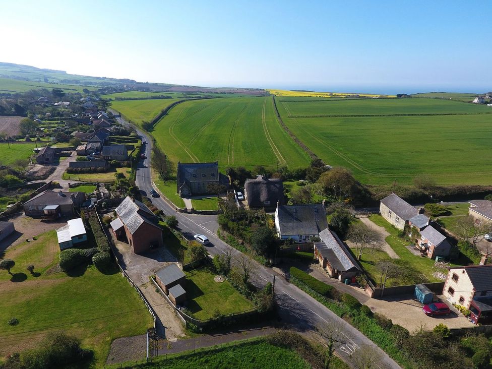 An aerial view of a village road with houses and green fields at Chapel House in Chale