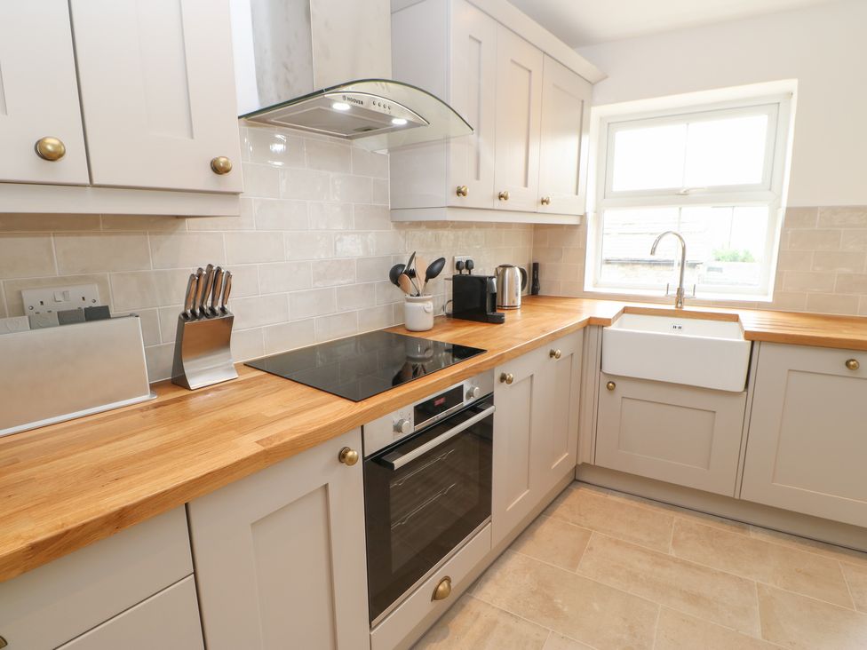 A kitchen with wooden countertops stove oven sink and cabinets at The Old Store 2 Alpine Terrace in Reeth