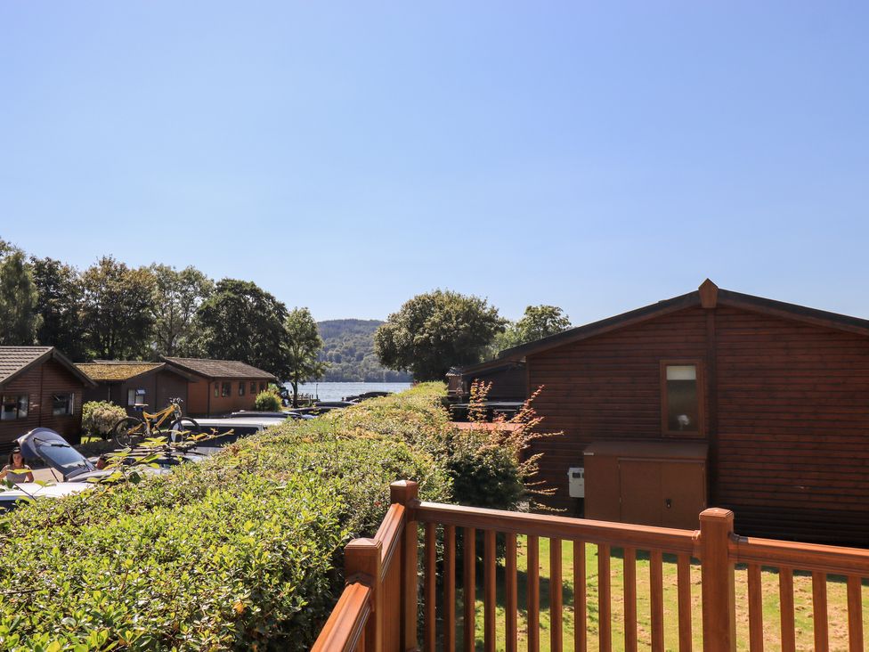 View of wooden cabins near a lake with trees and hills in the background at Robins Nest in Bowness 71 White Cross Bay near Windermere