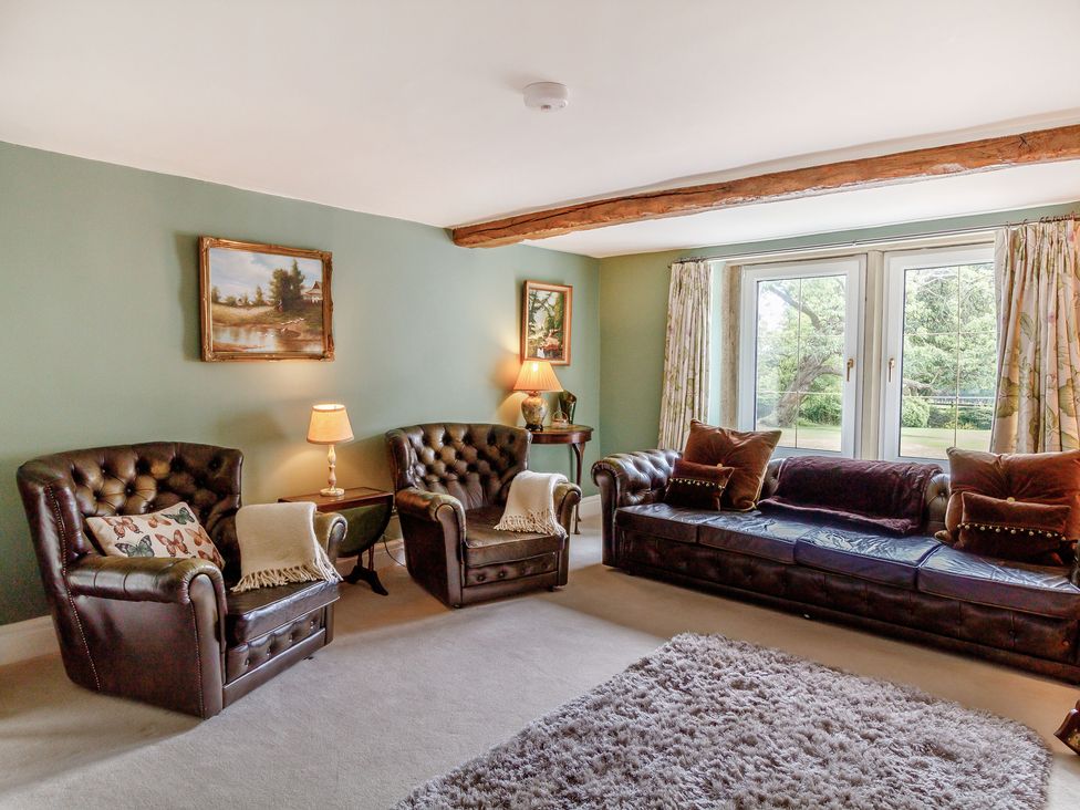 A living room with leather sofas and armchairs a rug and a coffee table at Fence House in Fence