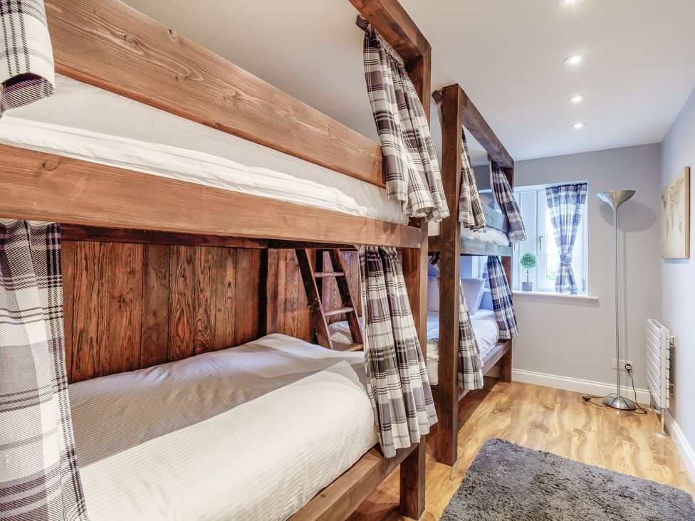 A bedroom with wooden bunk beds and plaid curtains at Fence House in Fence
