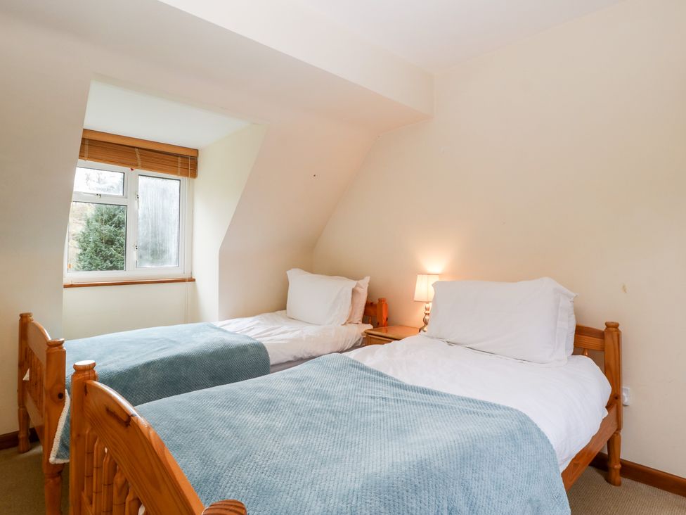 A bedroom with two single wooden beds and a bedside table with a lamp at The Studio - Arne in Arne near Stoborough