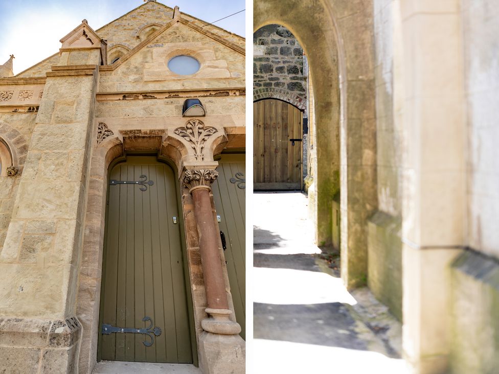 A pair of wooden doors in stone archways on a historic building and a wooden door at the end of a stone corridor at Bishops Retreat in Ventnor