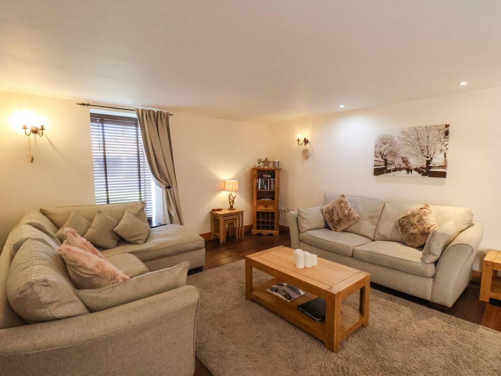 A living room with sofas coffee table and wall art at The Old Dairy in Ellerby Runswick Bay
