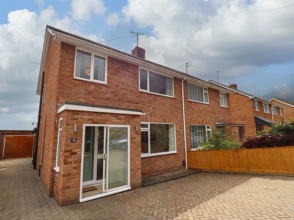 A brick semi detached house with driveway and attached garage at Delabere Road in Bishops Cleeve