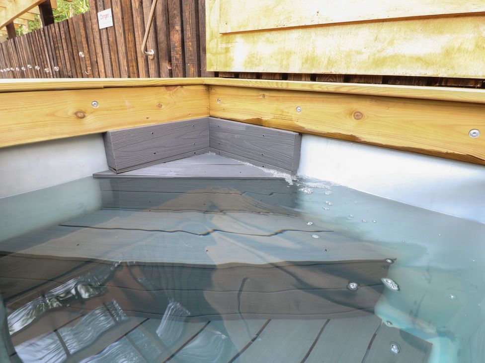 An outdoor hot tub with wooden paneling filled with water at Lodge 7 - The Earn in Errol