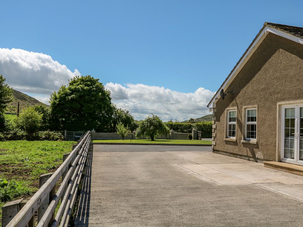 An outdoor area with a concrete driveway beside a house and green trees in the background at Willow Tree Farm House in Newry near Jonesborough