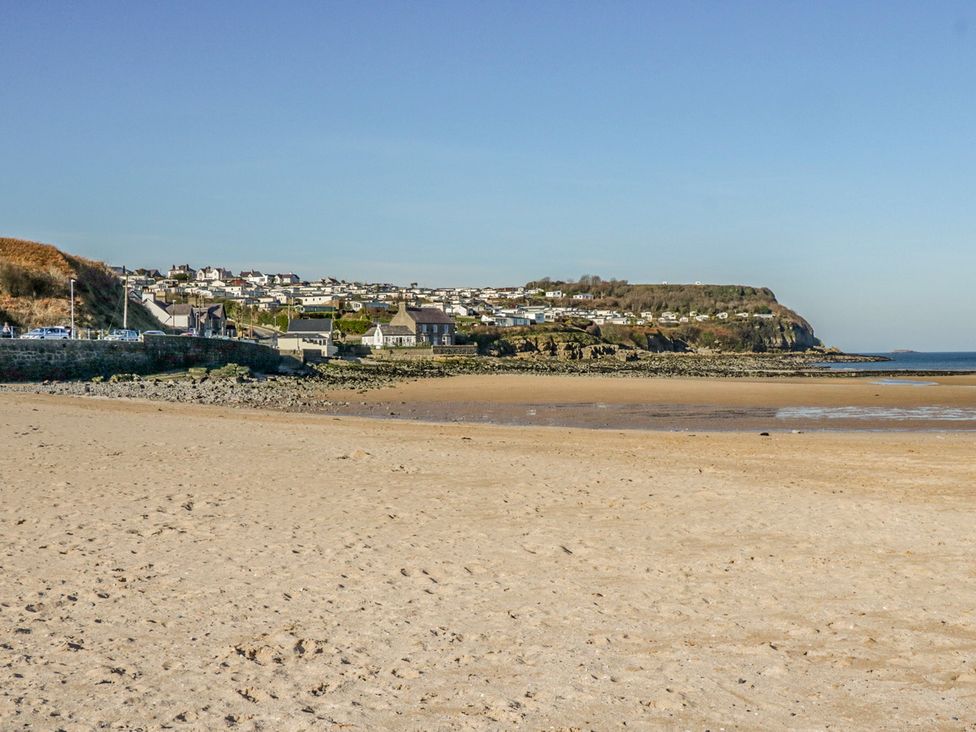A sandy beach with houses on hills and a rocky shoreline at Willow Tree Farm House in Newry near Jonesborough
