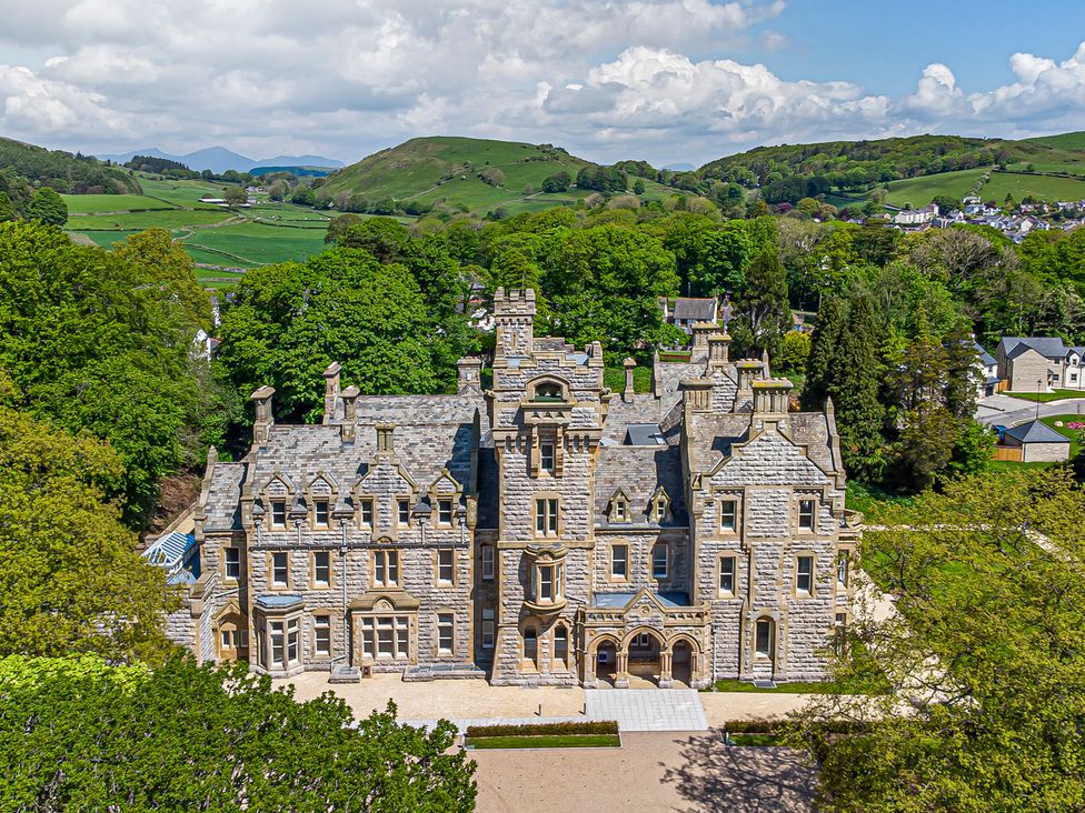 A large stone mansion surrounded by trees and hills at The Violet Suite Stone Cross Mansion in Ulverston