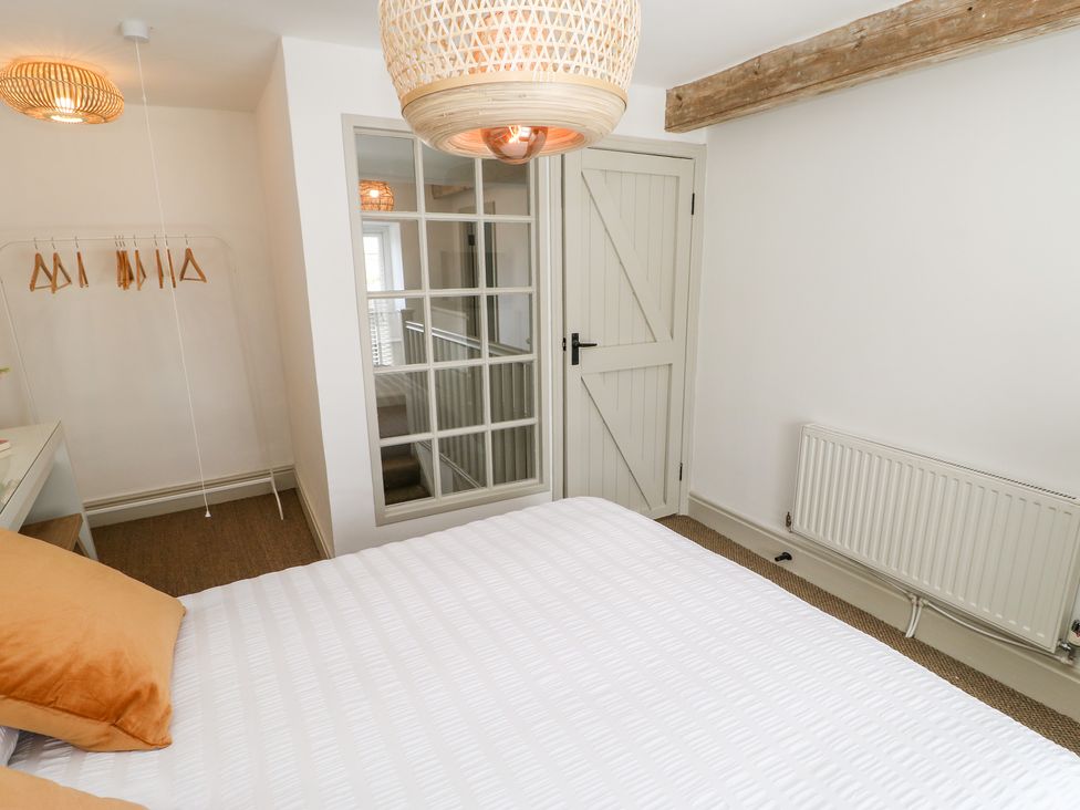 A bedroom with a bed a door a radiator and a clothes rack at Dale Cottage in Ingleton County Durham