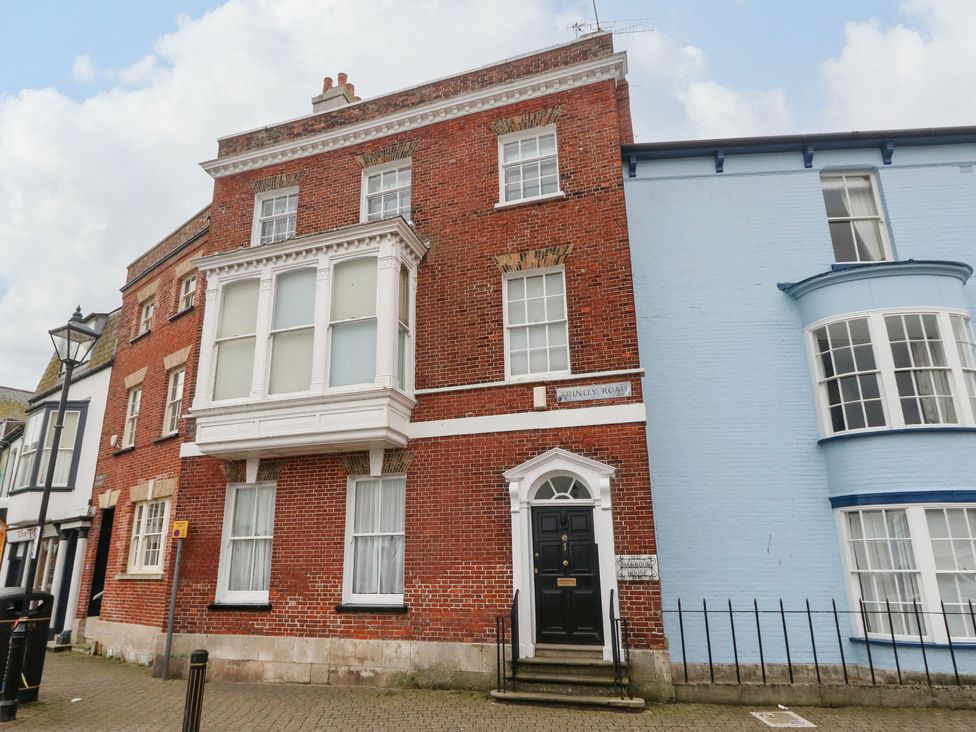 A street view of brick and painted buildings with windows and a black door at Embassy Brewers Quay Harbour