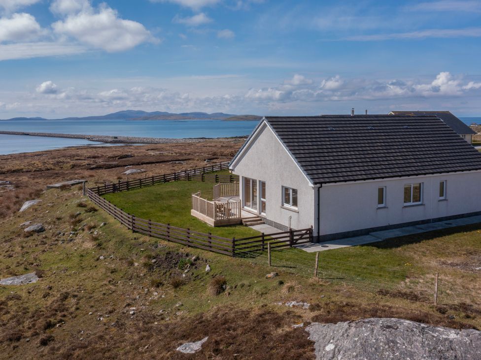 A house with a fenced yard near a rocky coastline overlooking the sea at Rockpool in Glendale Isle of South Uist